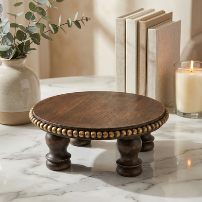 Handcrafted wooden pedestal with decorative gold beading, styled on marble with books and candle