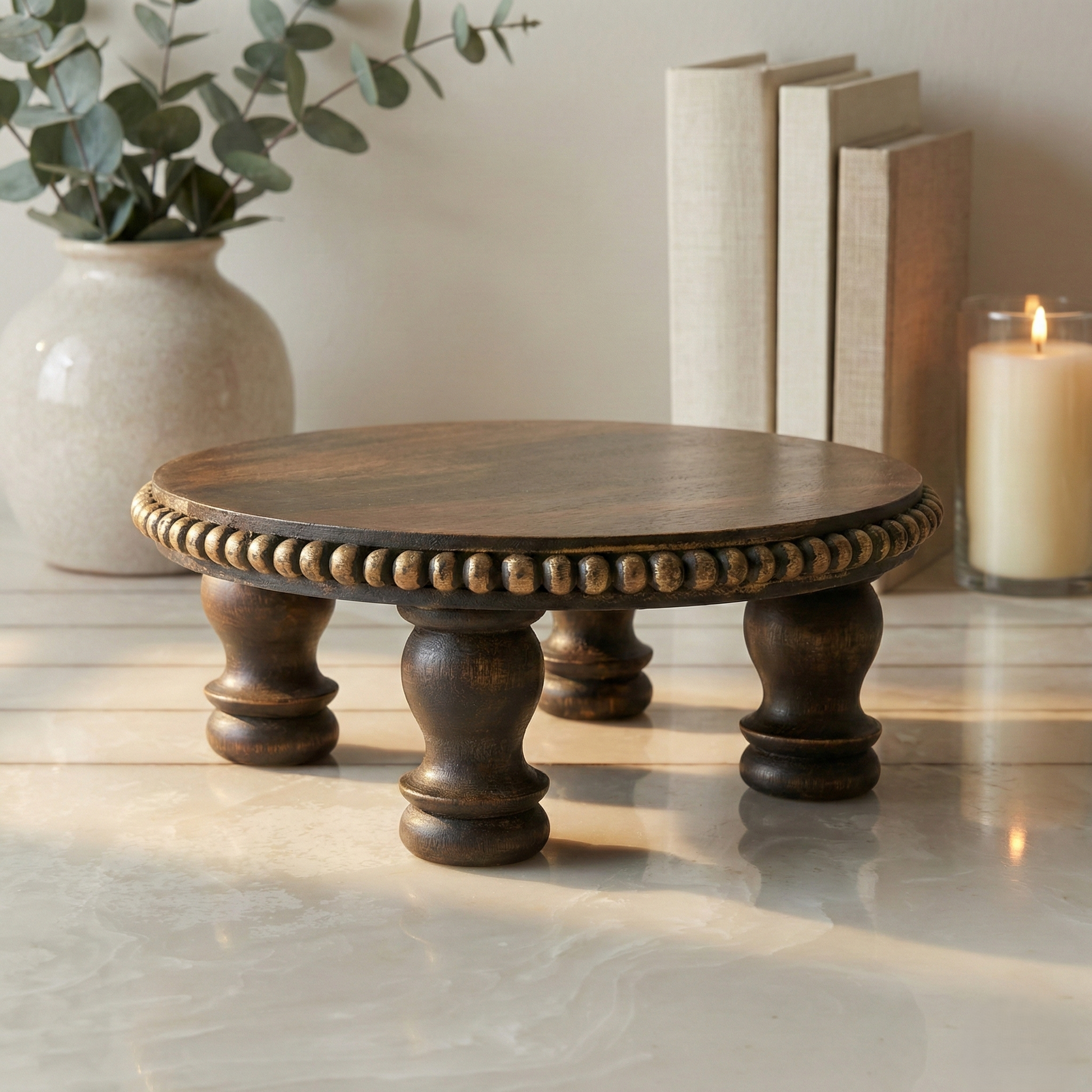 Handcrafted round wooden decorative riser with ornate beaded edge on marble surface