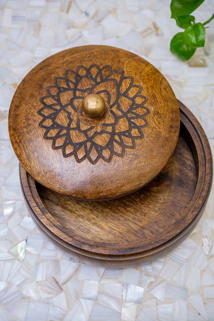 Handcrafted wooden box with carved floral design on lid, placed on a mosaic surface