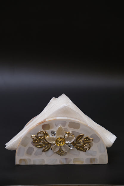 Handcrafted mother of pearl floral napkin holder with gold accents against black background