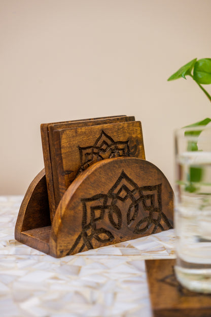 Handcrafted wooden coasters with carved floral design in holder on tabletop