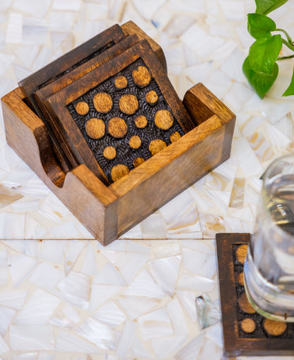 Handcrafted wooden coasters with circular pattern on a mother of pearl table