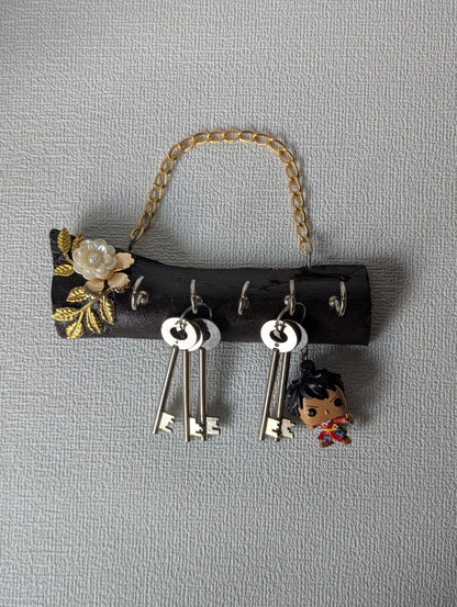 Handcrafted wooden key holder with gold floral design, metal chain, and hanging keys
