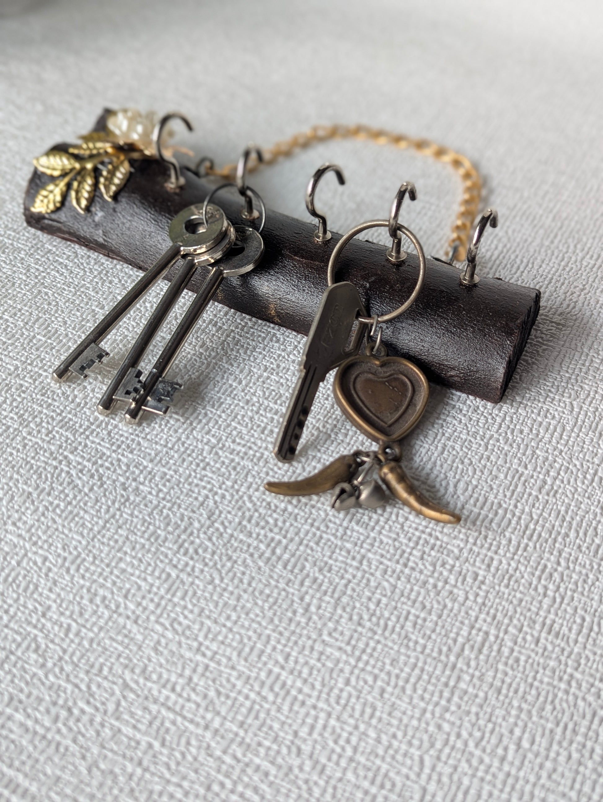 Handcrafted wooden key holder with metal hooks and decorative floral accents