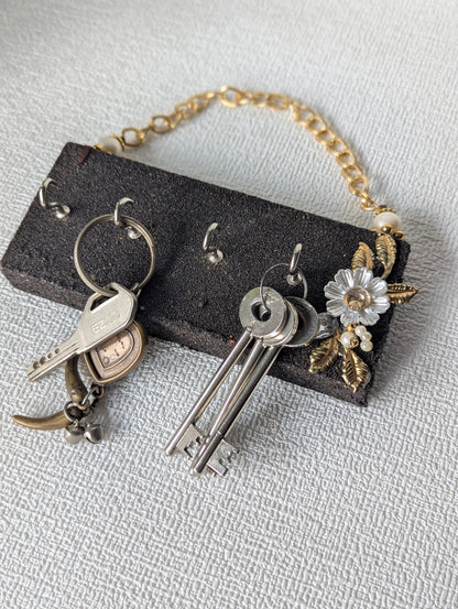 Handcrafted wooden key holder with floral decoration, gold chain and multiple keys