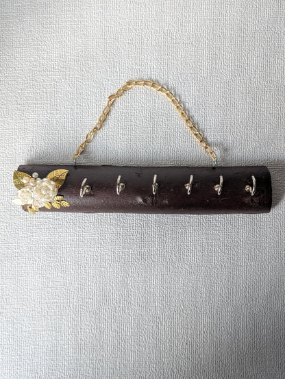 Handcrafted wooden key holder with floral embellishment and gold chain, wall mounted decor