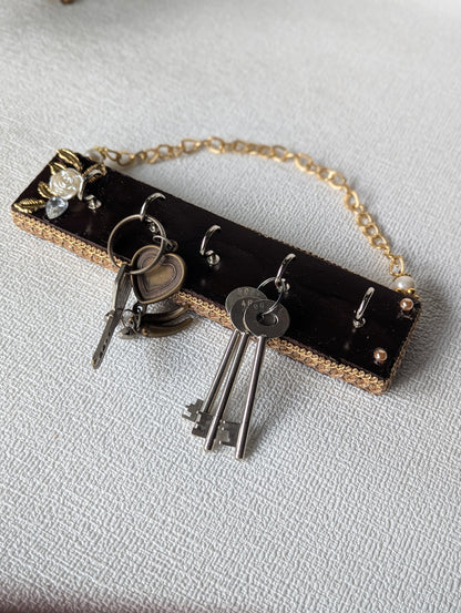 Handcrafted wooden key holder with floral embellishment and attached metal keys