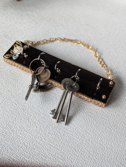Handcrafted wooden key holder with floral embellishment and attached metal keys