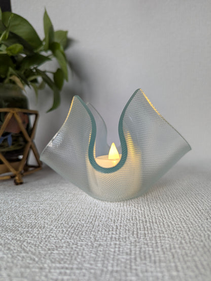 Handcrafted glass tealight holder with lit candle, elegant home decor accent