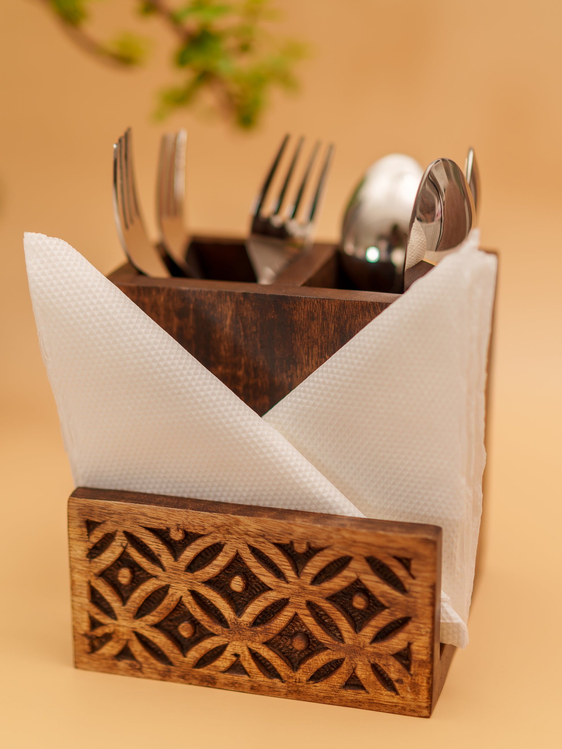 Handcrafted wooden cutlery holder with floral carvings, holding napkins and utensils