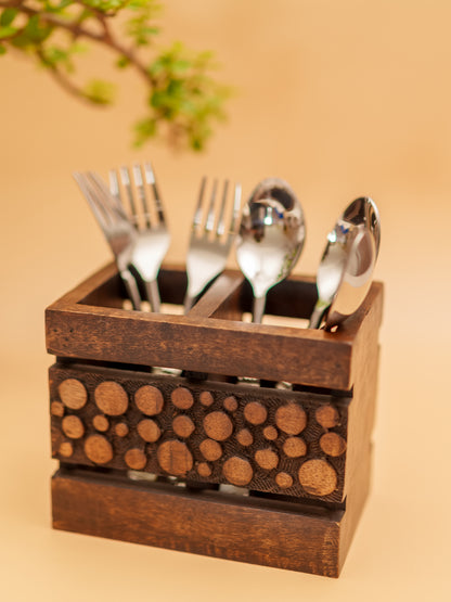 Handcrafted wooden cutlery holder with carved dot pattern, holding spoons and forks