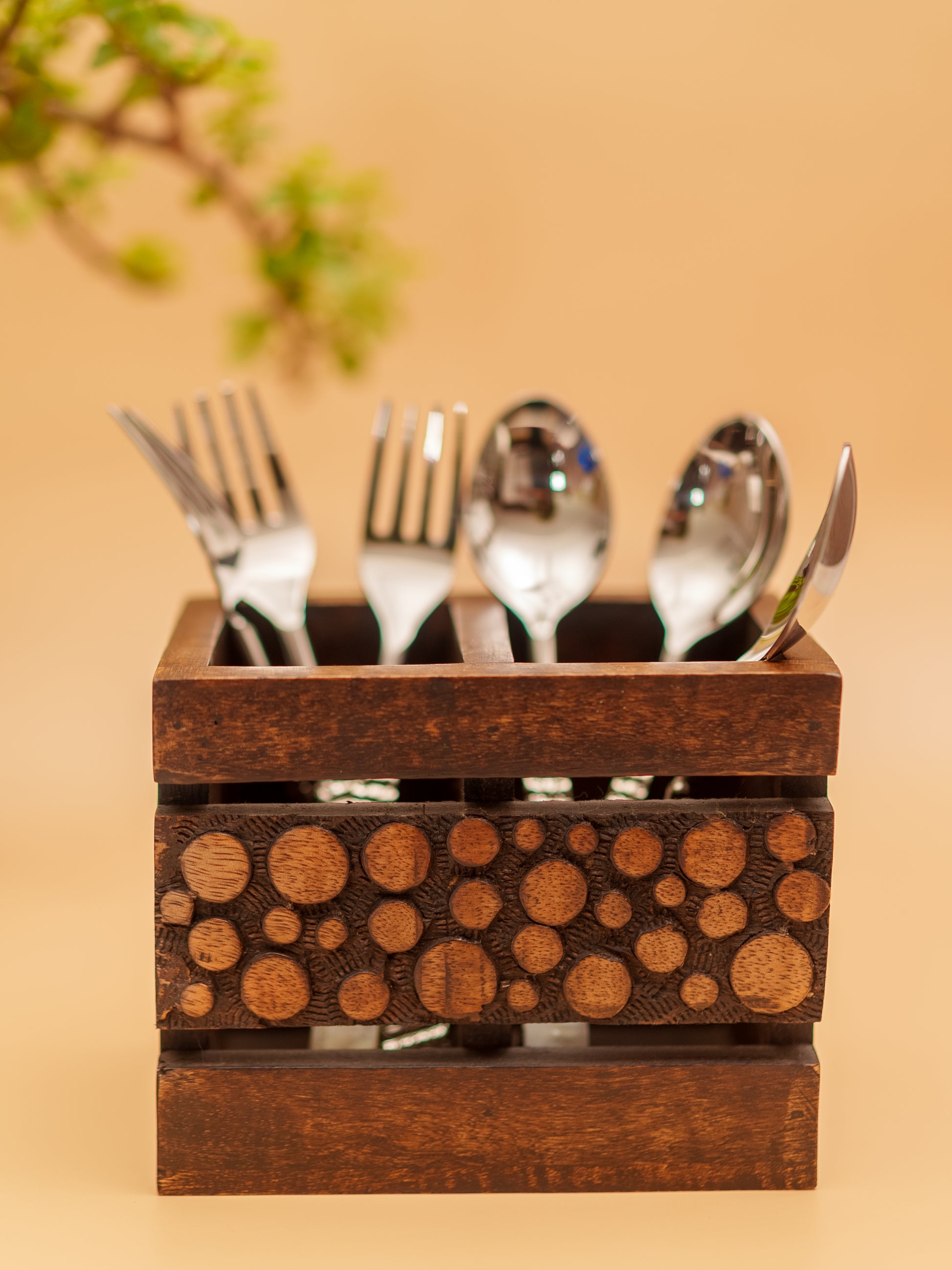 Handcrafted wooden cutlery holder with engraved circular patterns, holding forks, spoons, knives