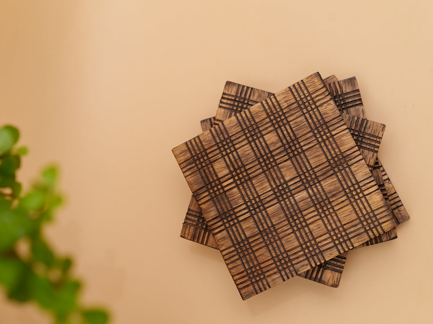 Handcrafted wooden coasters with etched geometric pattern on beige background