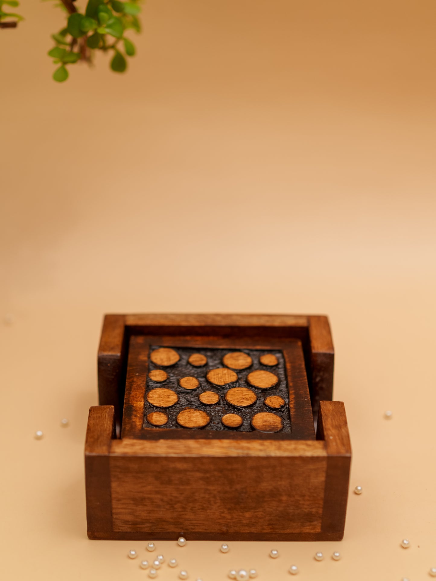 Handcrafted wooden coaster set with circular inlay design on beige background