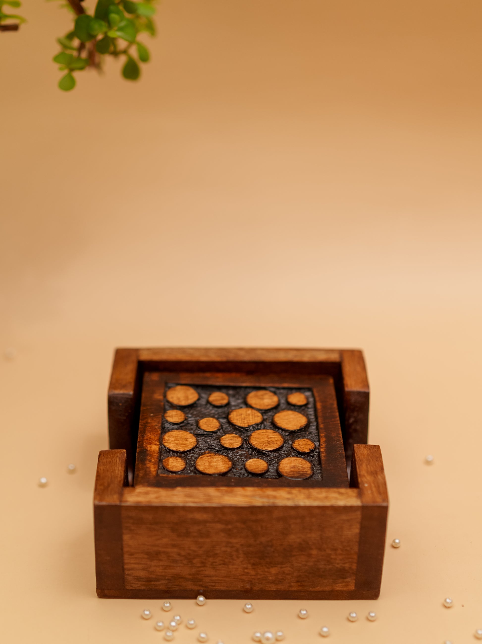 Handcrafted wooden coaster set with circular inlay design on beige background