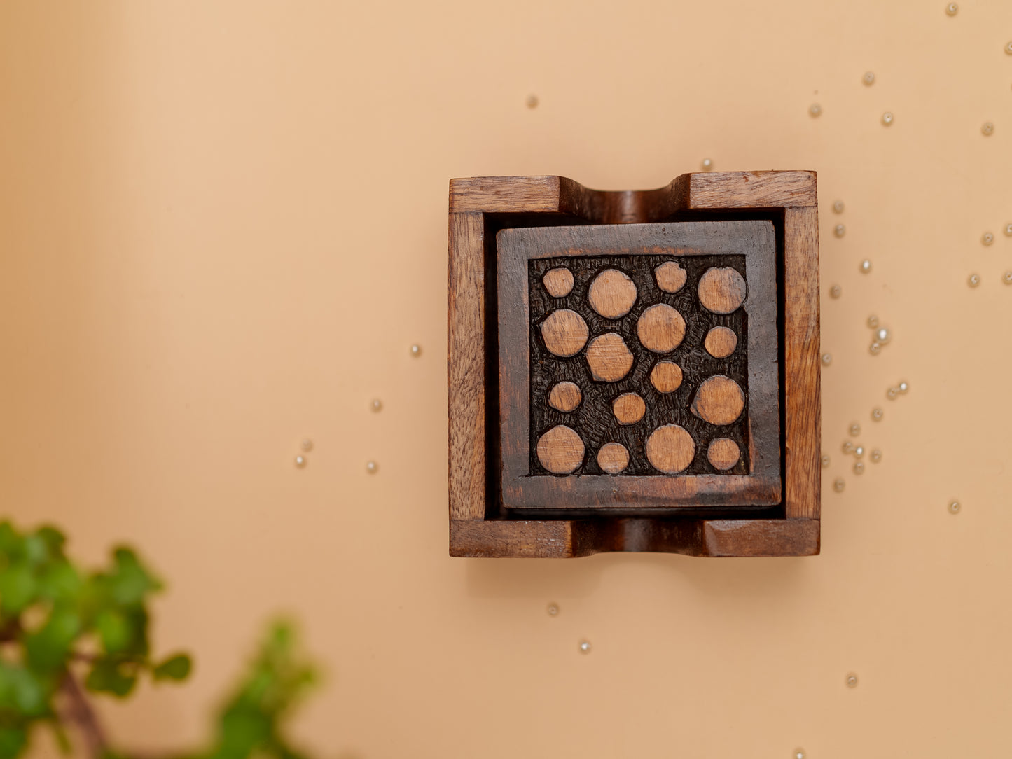 Handcrafted wooden decorative box with circular carvings on beige background