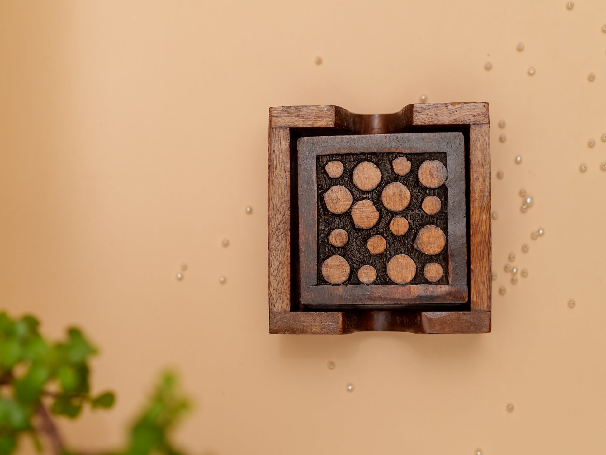 Handcrafted wooden decorative box with circular carvings on beige background